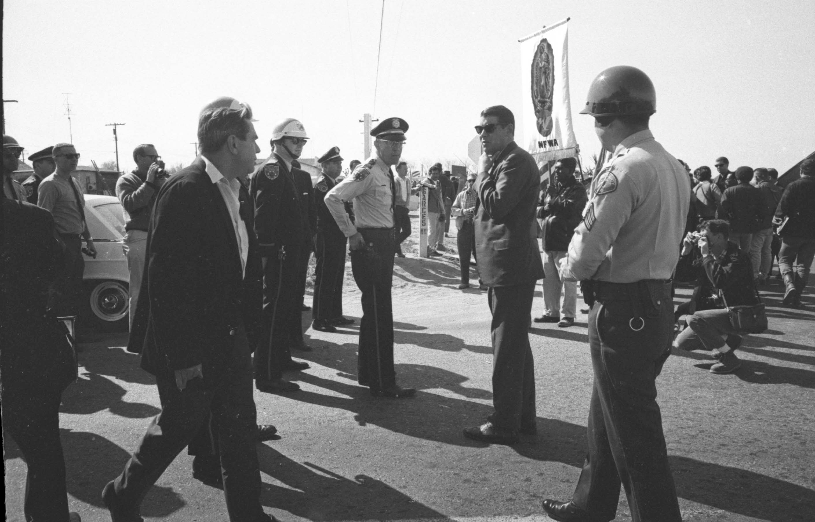 Delano police officers blocking strikers on the first day of the pilgrimage to Sacramento, Delano, 1966