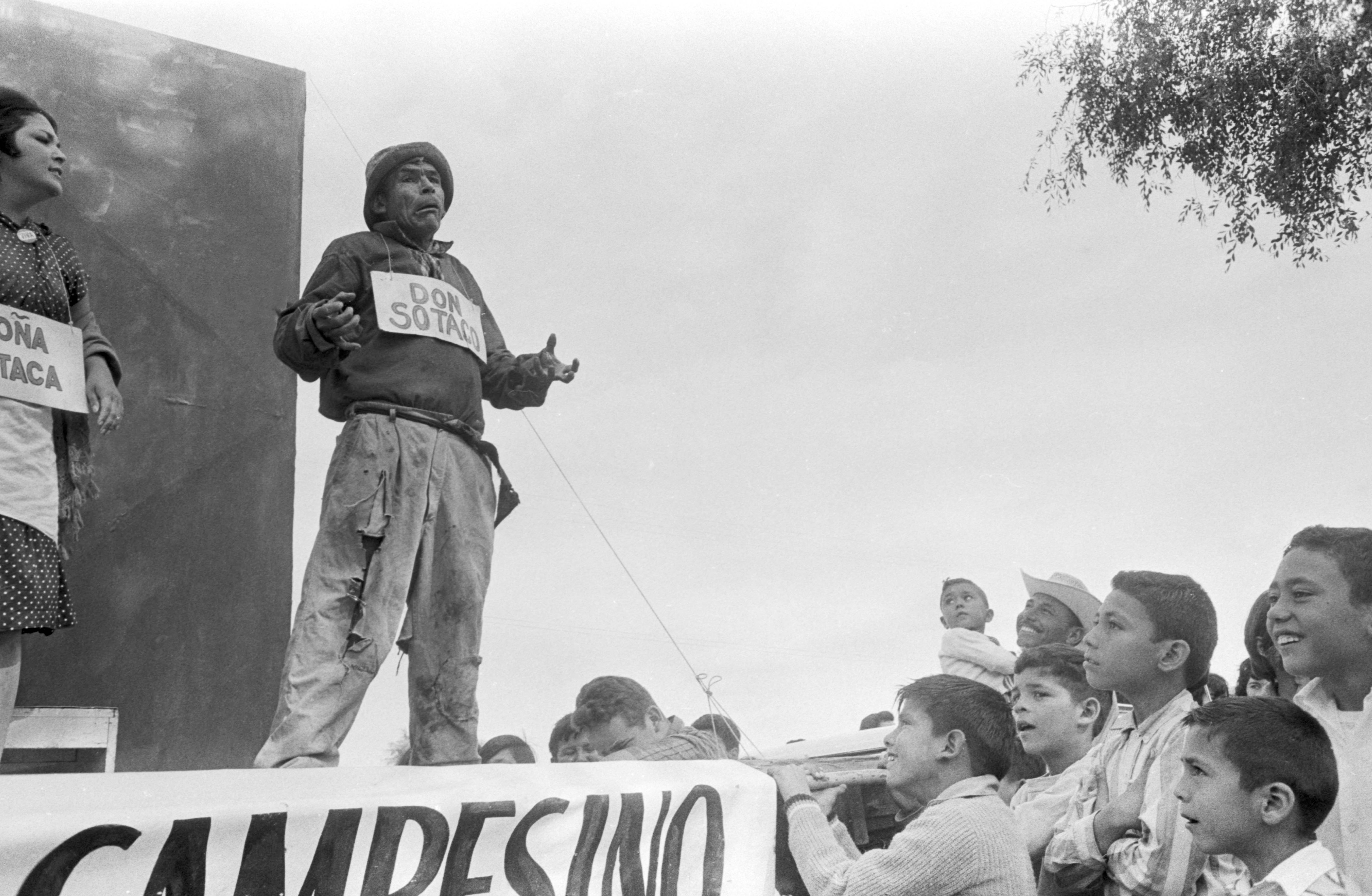 Felipe Cantú "Don Sotaco" and Clarisse Luna "Doña Sotaca" performing in The Fifth Season on the flatbed of a truck, Salinas, ca. 1966. Felipe Cantú "Don Sotaco" y Clarisse Luna "Doña Sotaca" actuando en La Quinta Temporada en la plataforma de un camión, Salinas, circa 1966.