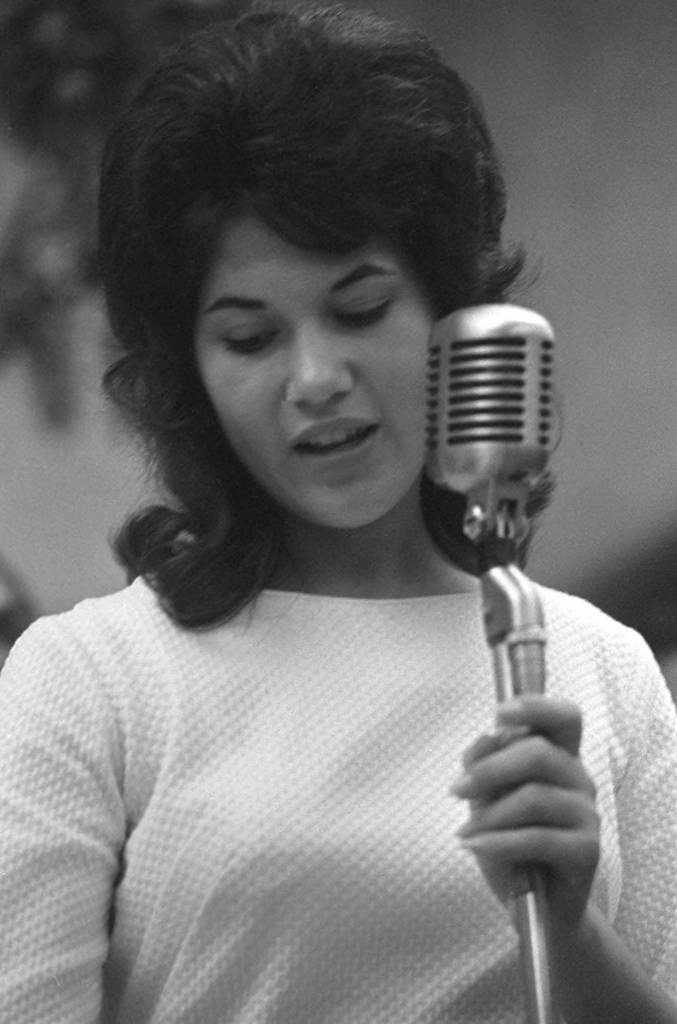 Yolanda Barrera speaks into a microphone during a UFW meeting at Filipino Hall. Yolanda Barrera habla ante un micrófono durante una junta de la Unión de Campesinos (UFW en inglés) en Filipino Hall.