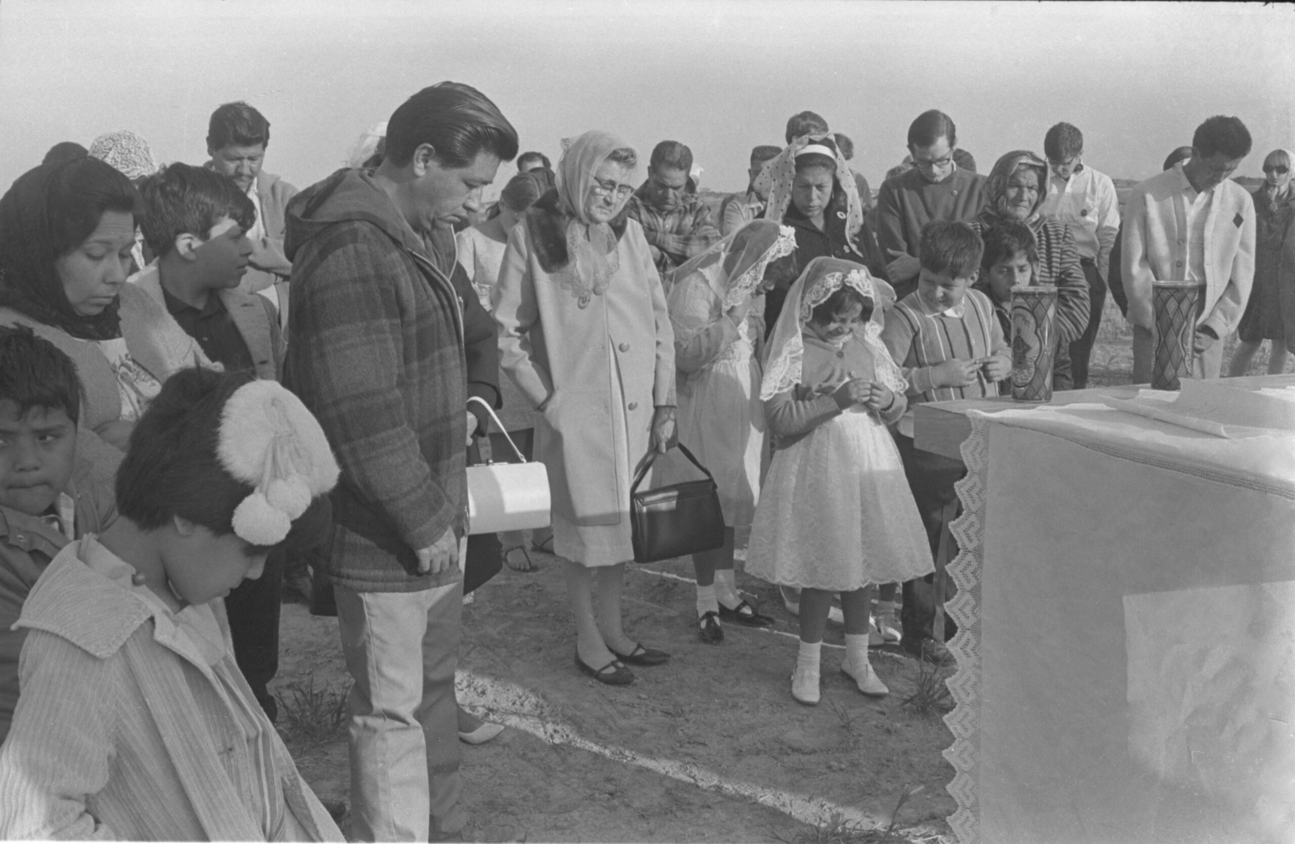 César Chávez (plaid jacket) and farm workers celebrate Easter mass at sunrise at<br />
Forty Acres. Delano, California, April 14, 1968. </p>
<p>César Chávez (chaqueta a cuadros) y campesinos celebran la misa de pascua al amanecer en Forty Acres. Delano, California, 14 de abril de 1968.